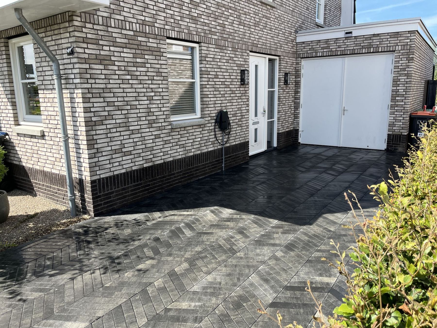 Oprit met donkere straatstenen naar de garage in Ridderkerk